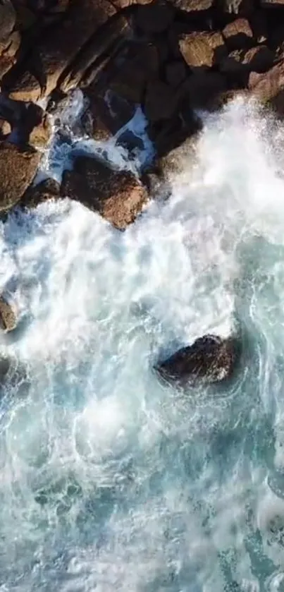 Aerial view of ocean waves crashing against rugged rocks.