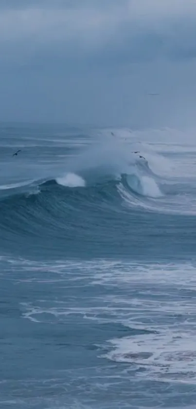 Blue ocean waves crashing under a cloudy sky.