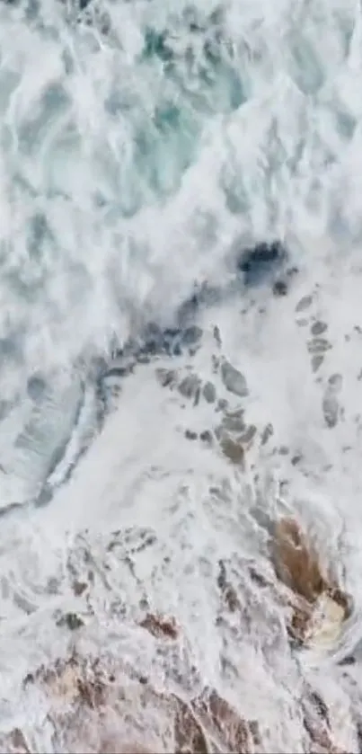 Aerial view of crashing ocean waves in white and blue hues, creating a calming effect.