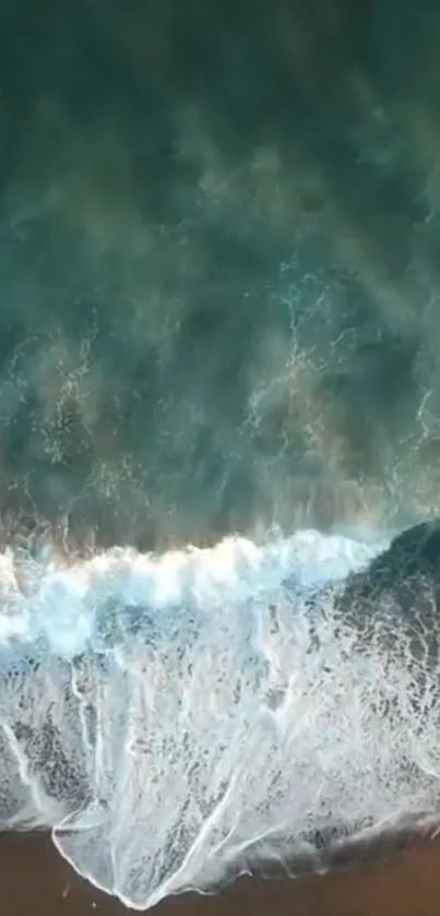 Aerial wallpaper of ocean waves crashing on a beach shore, serene view.