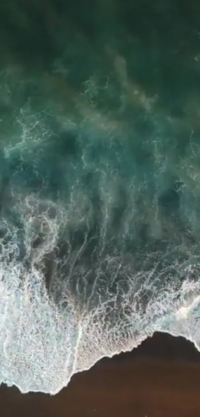 Aerial view of white ocean waves on a turquoise sea, creating serene patterns.