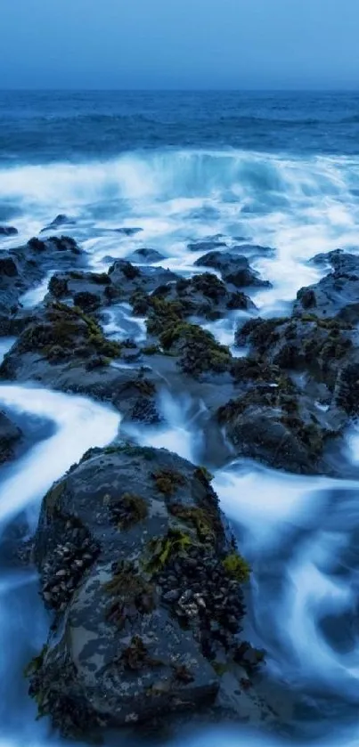Ocean waves crashing over rocky shore in serene blue hues.