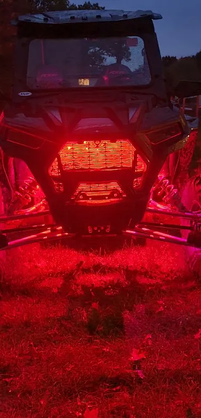 Off-road vehicle glowing red lights in a night scene on a grassy terrain.