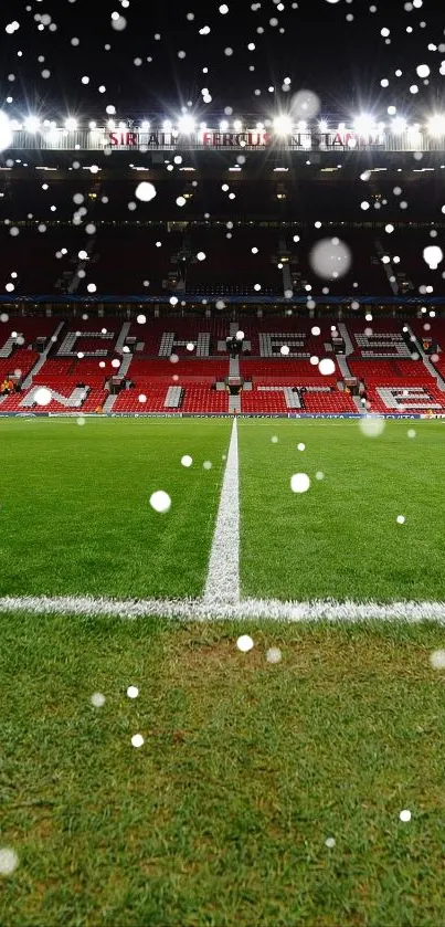 Panoramic view of Old Trafford football field at night with bright stadium lights.