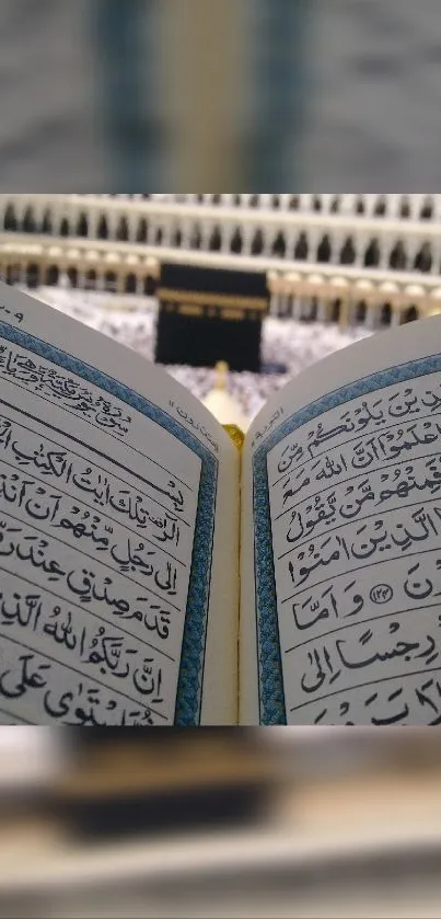 Open Quran with blurred Kaaba in background on mobile wallpaper.