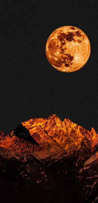 Orange moon rising over dark mountains at night.