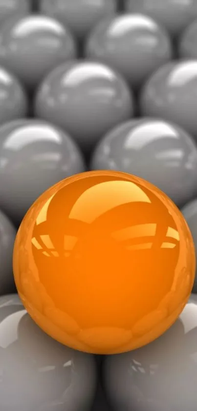 Vibrant orange sphere among glossy grey spheres.