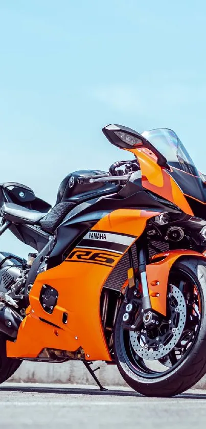 Orange sports bike on road under clear sky.