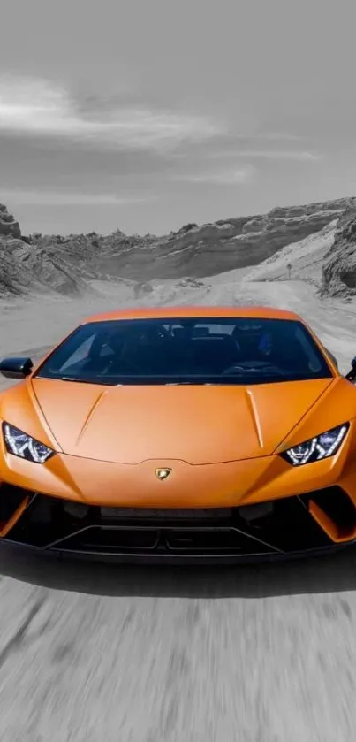 Orange sports car on a mountain road with a gray sky.