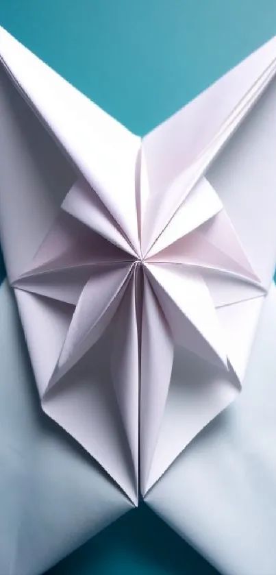 Folded white origami butterfly on a teal blue background.