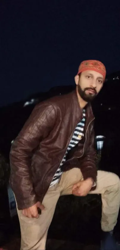 A person in rugged attire posing at night outdoors.