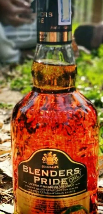 Golden brown whiskey bottle outdoors in nature.