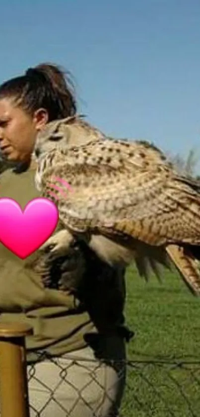 Owl perched on handler with clear sky.