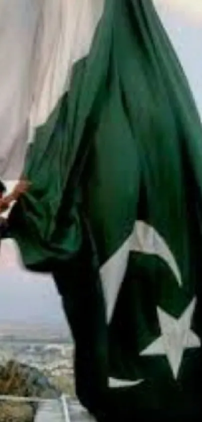 Soldier raising the Pakistani flag on a pole with pride.