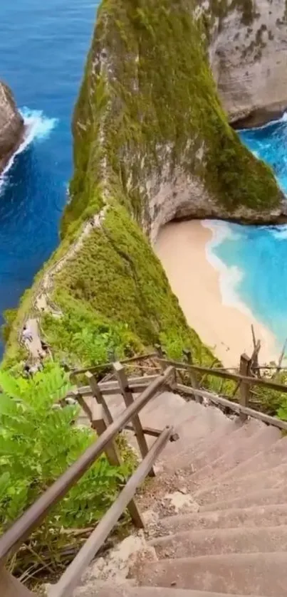 Tropical beach with turquoise ocean and lush green cliffs viewed from wooden stairs.