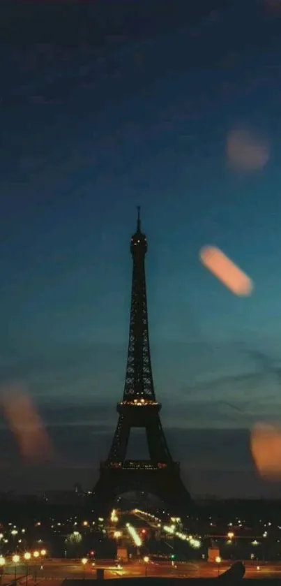 Eiffel Tower with glowing city lights against a deep blue evening sky.