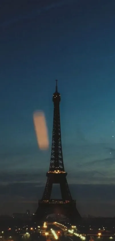 Eiffel Tower illuminated against a moody night sky.