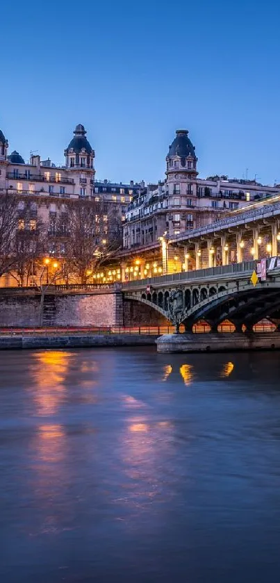 Paris evening skyline with lit bridge over the Seine.