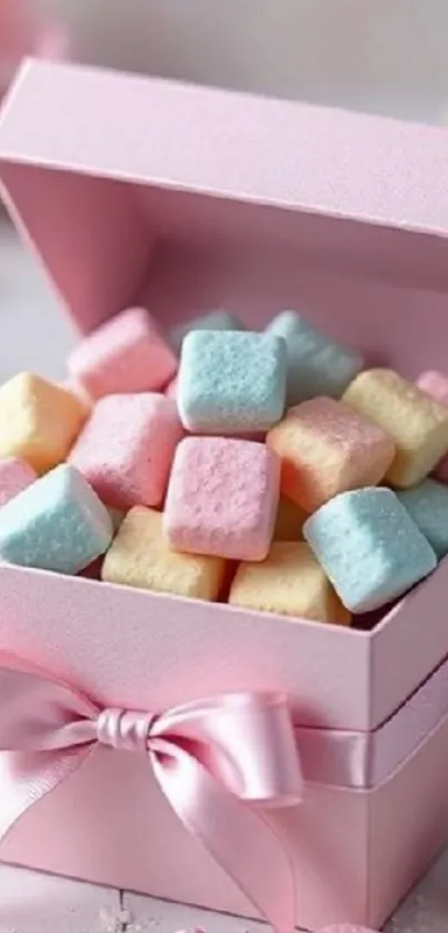 Pastel candy pieces in a pink gift box with a ribbon.