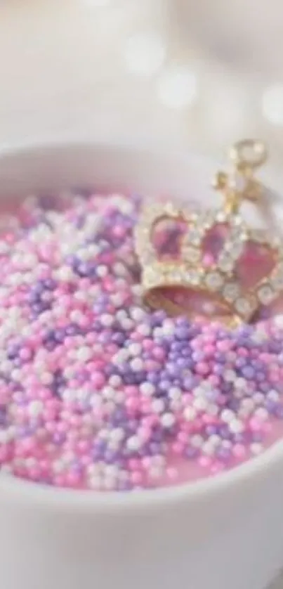 Pastel pink and purple sprinkles with a golden crown in a bowl.