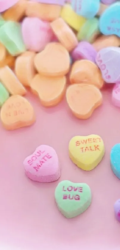 Pastel heart-shaped candy on a pink background.