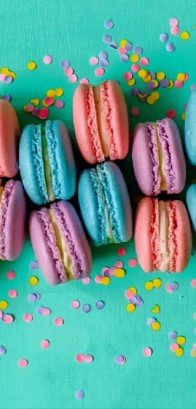 Colorful pastel macarons with teal and confetti background.