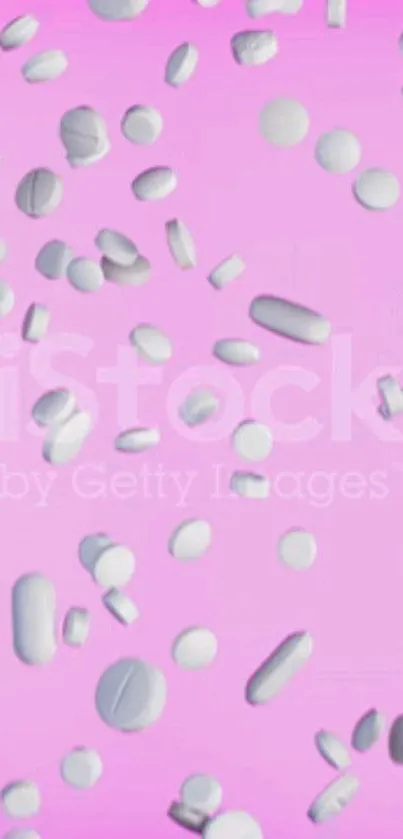 White pills scattered on a pastel pink background.