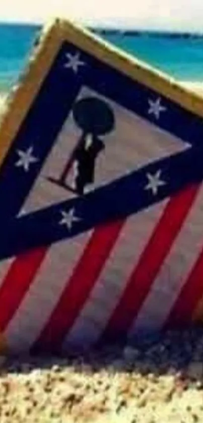 Patriotic shield on a sandy beach with blue ocean background.