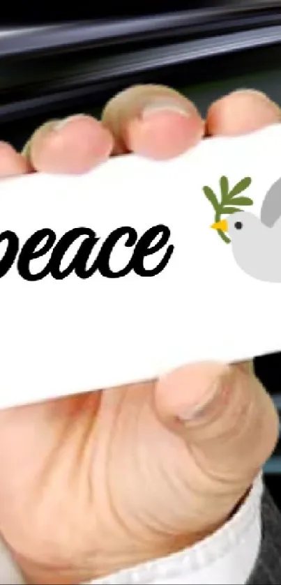 Hand holding a card with 'peace' and a dove illustration.