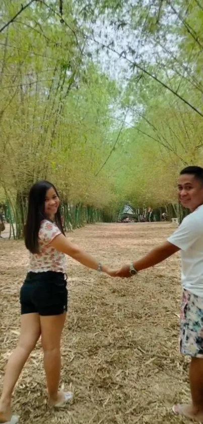 Couple holding hands in a bamboo forest pathway.