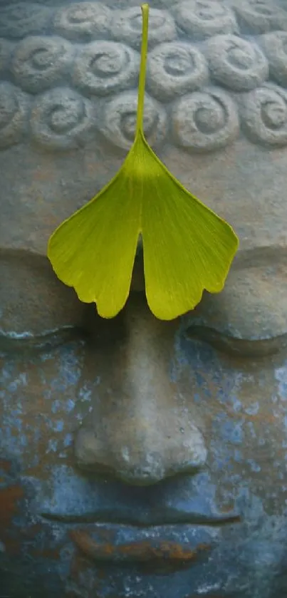 Buddha statue with a green leaf accent on the forehead, exuding tranquility.