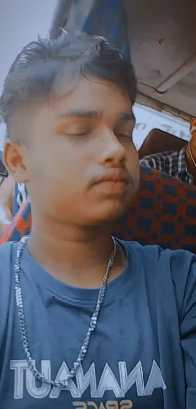 Young man sits peacefully on a bus, capturing a serene travel moment.