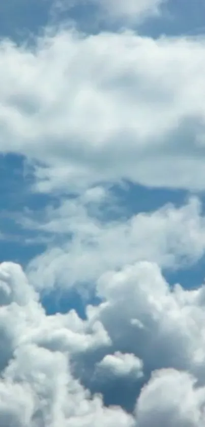 Peaceful blue sky with fluffy white clouds.