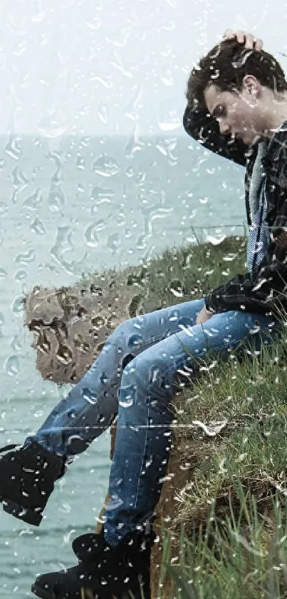 Man sitting on a seaside cliff in thoughtful reflection.