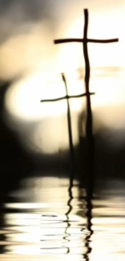 Two crosses reflecting on calm water with a warm white glow.