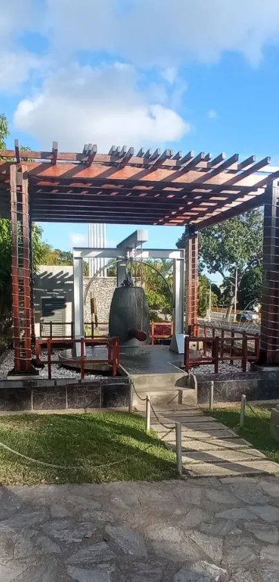 Sunlit garden with wooden pergola and bell structure.