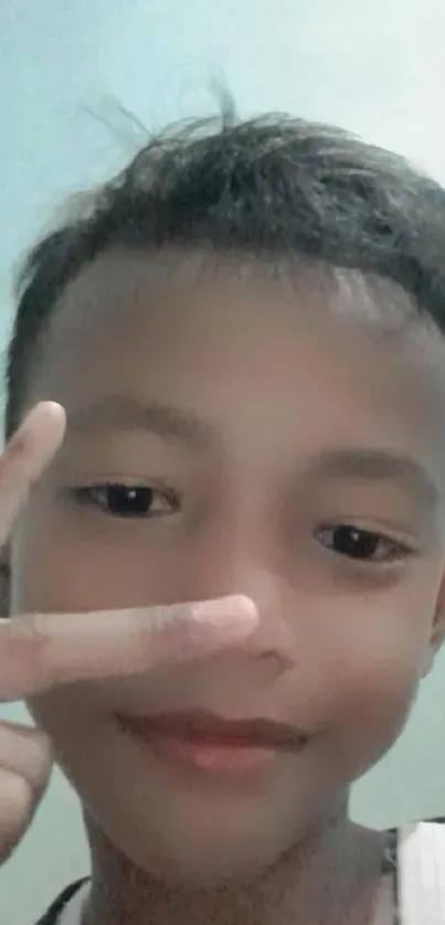 Kid showing peace sign with a calm smile.