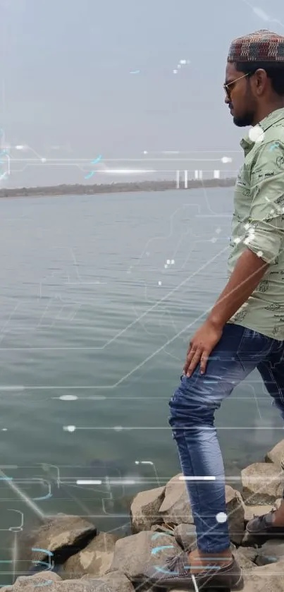 Man stands on rocky lakeside, admiring tranquil water.