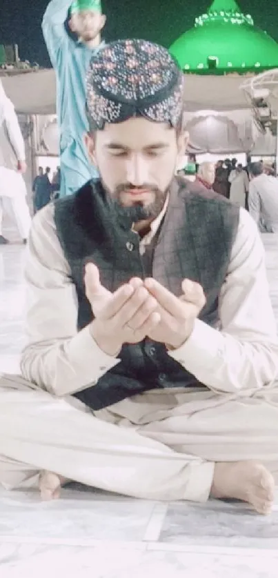 Man meditating at spiritual shrine in peaceful evening setting.