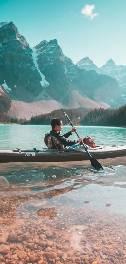 Person kayaking on a serene mountain lake with a stunning backdrop.