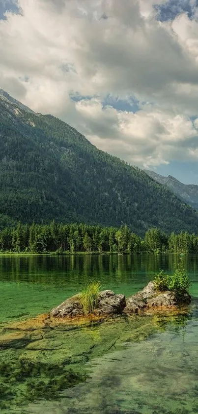 Serene green mountain lake with forest and rocky shore.