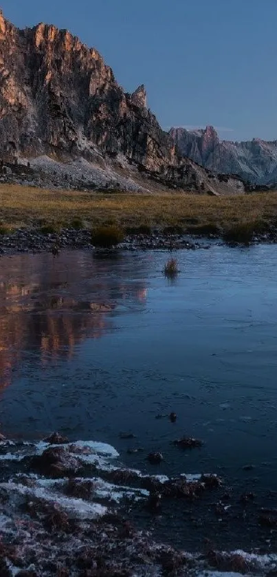 Serene mountain landscape reflecting in a peaceful lake at dusk.