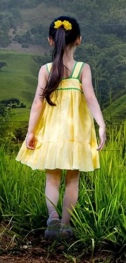 Girl in yellow dress standing in lush green field.