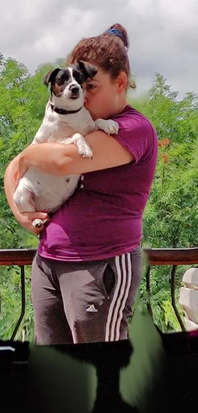 Woman hugging her dog in lush green outdoors.