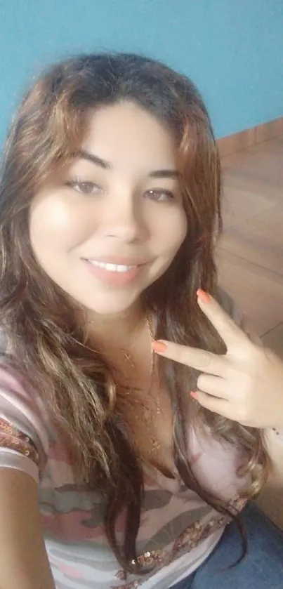 Smiling woman showing peace gesture indoors.