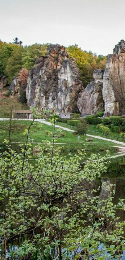 Towering rock formations above a calm lake with lush greenery.