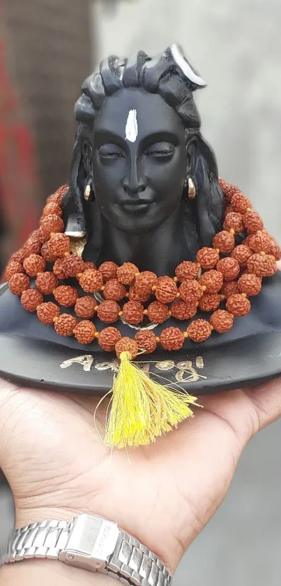 Shiva sculpture with rudraksha beads in hand.