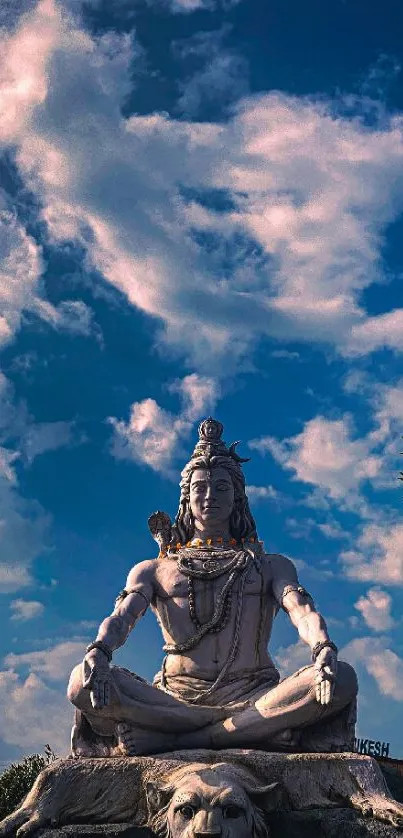 Serene Shiva statue with clouded blue sky backdrop.