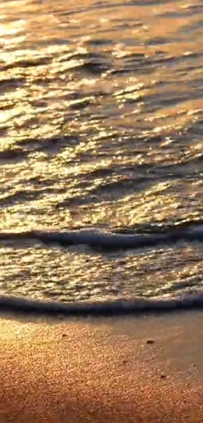 Sunset over waves on a sandy beach, creating a peaceful scene.