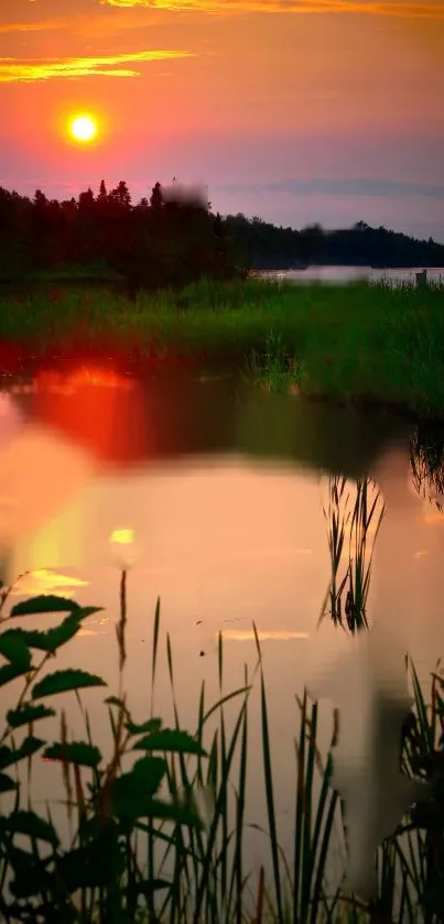 Serene sunset view over a tranquil lake with orange and green hues.